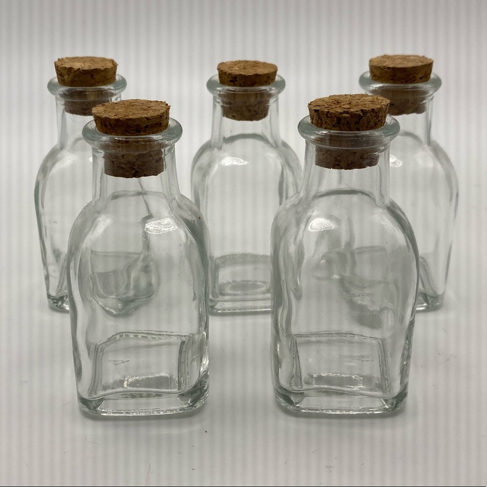 Five small jars with cork topper.